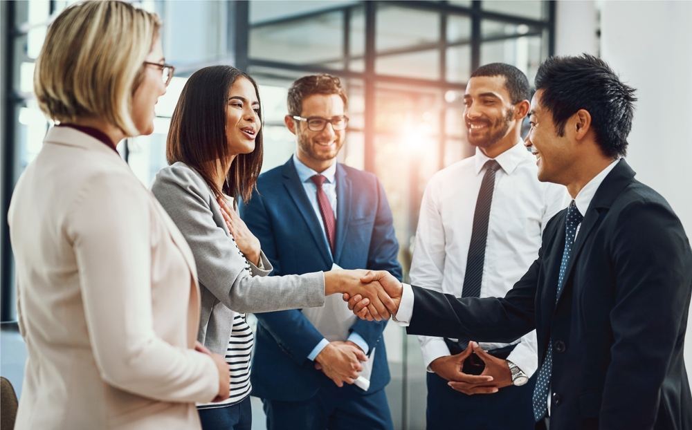 A group of professionals shake hands.