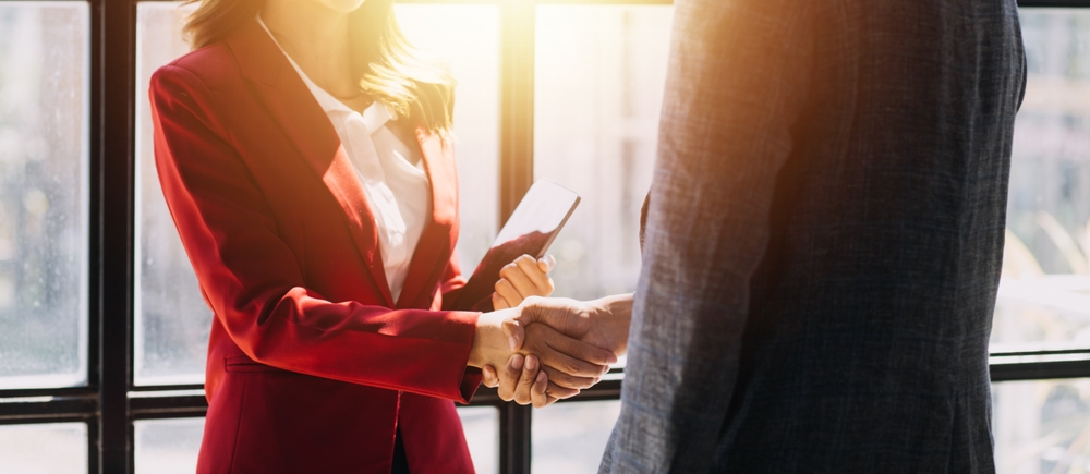 A businessman and businesswoman shake hands.